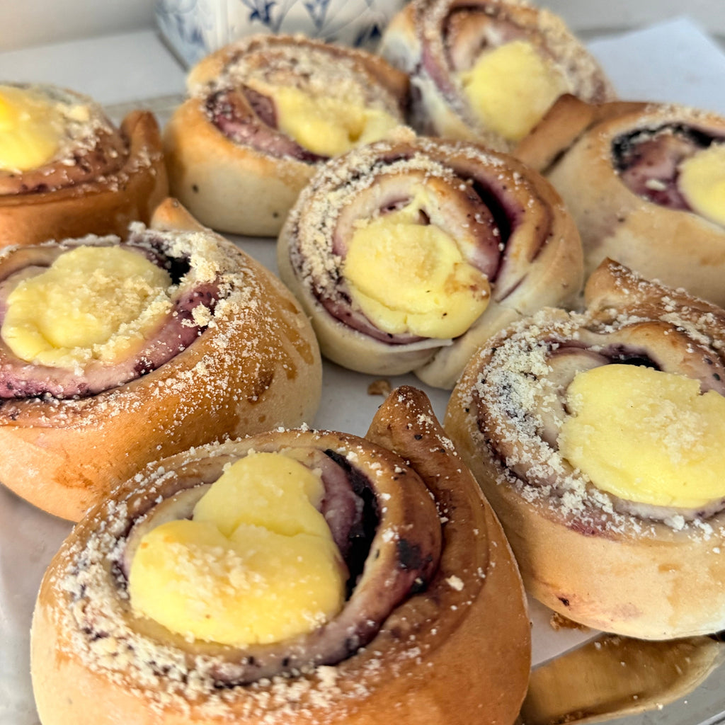 kierrepulla, jossa on mustikkahilloa ja päällä vaniljarahkatäyte keskus.