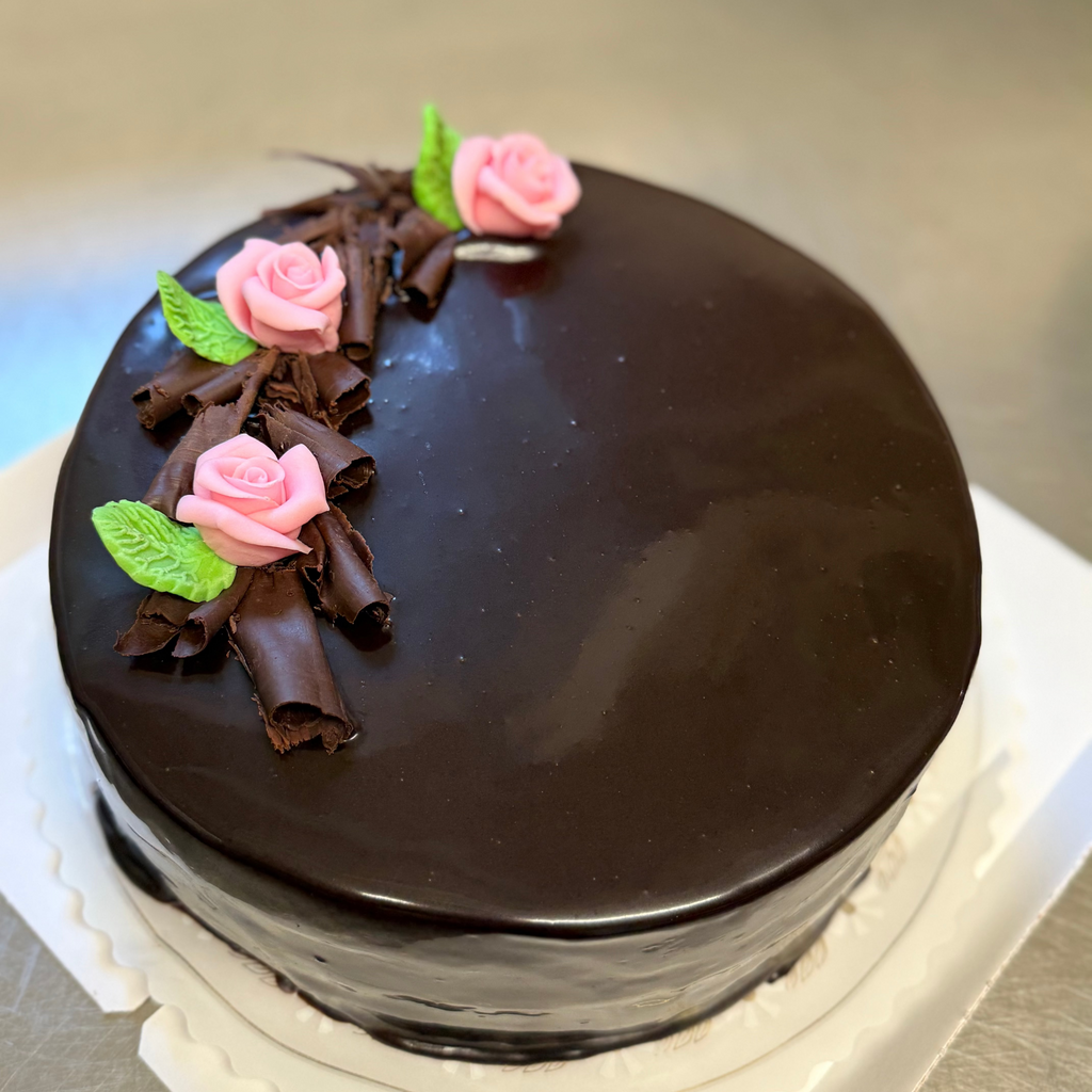 suklaakakku ganache kuorrutteella, suklaalastuilla ja sokerimassaruusuilla. 