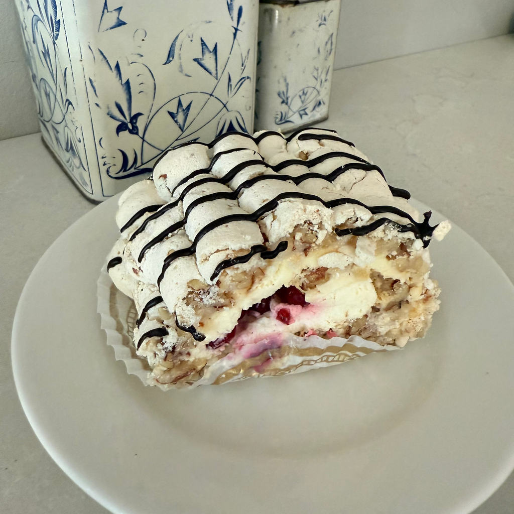 Marenkikääretorttu pala, puolukkaa ja kermaa sisällä, suklaaraidat päällä 