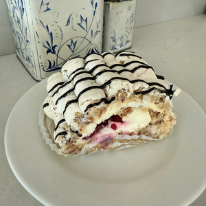 Marenkikääretorttu pala, puolukkaa ja kermaa sisällä, suklaaraidat päällä 
